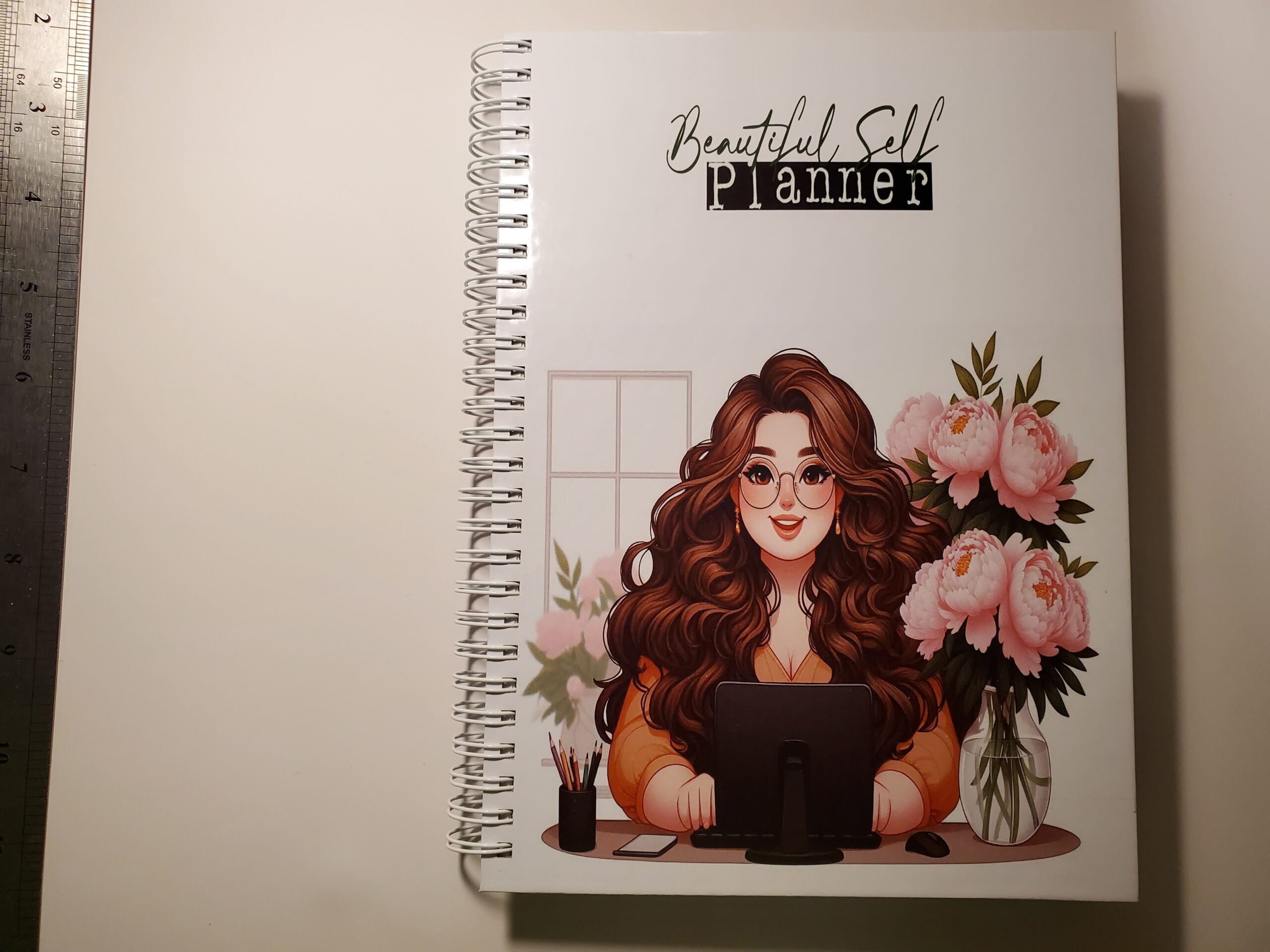 Double wired binder with image of a woman sitting at a computer desk