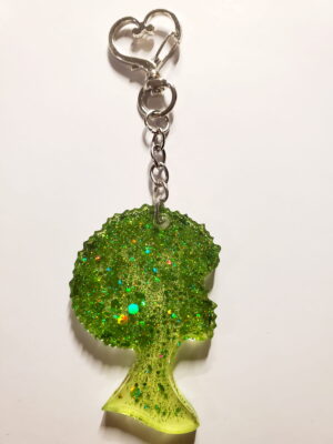 heart-shaped keychain hook with a resin mold shaped as a woman with an afro hair style with green glitter decorations