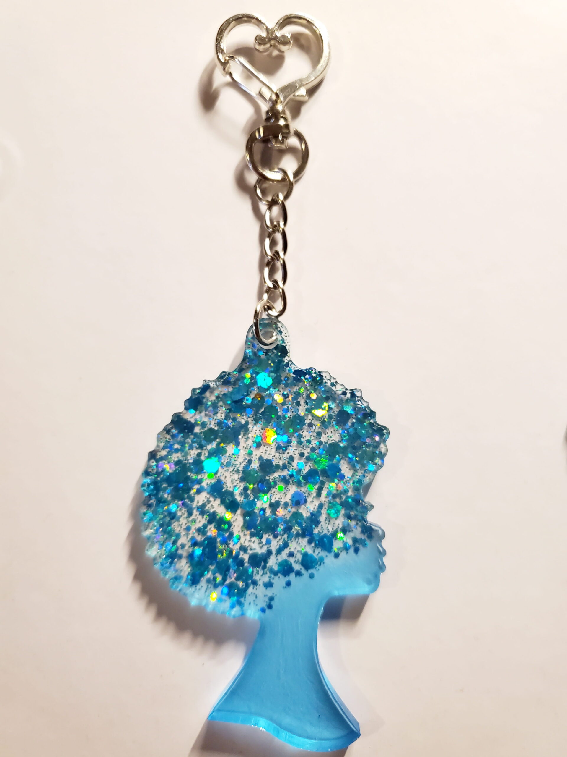 heart-shaped keychain hook with a resin mold shaped as a woman with afro hair style with light blue glitter decorations