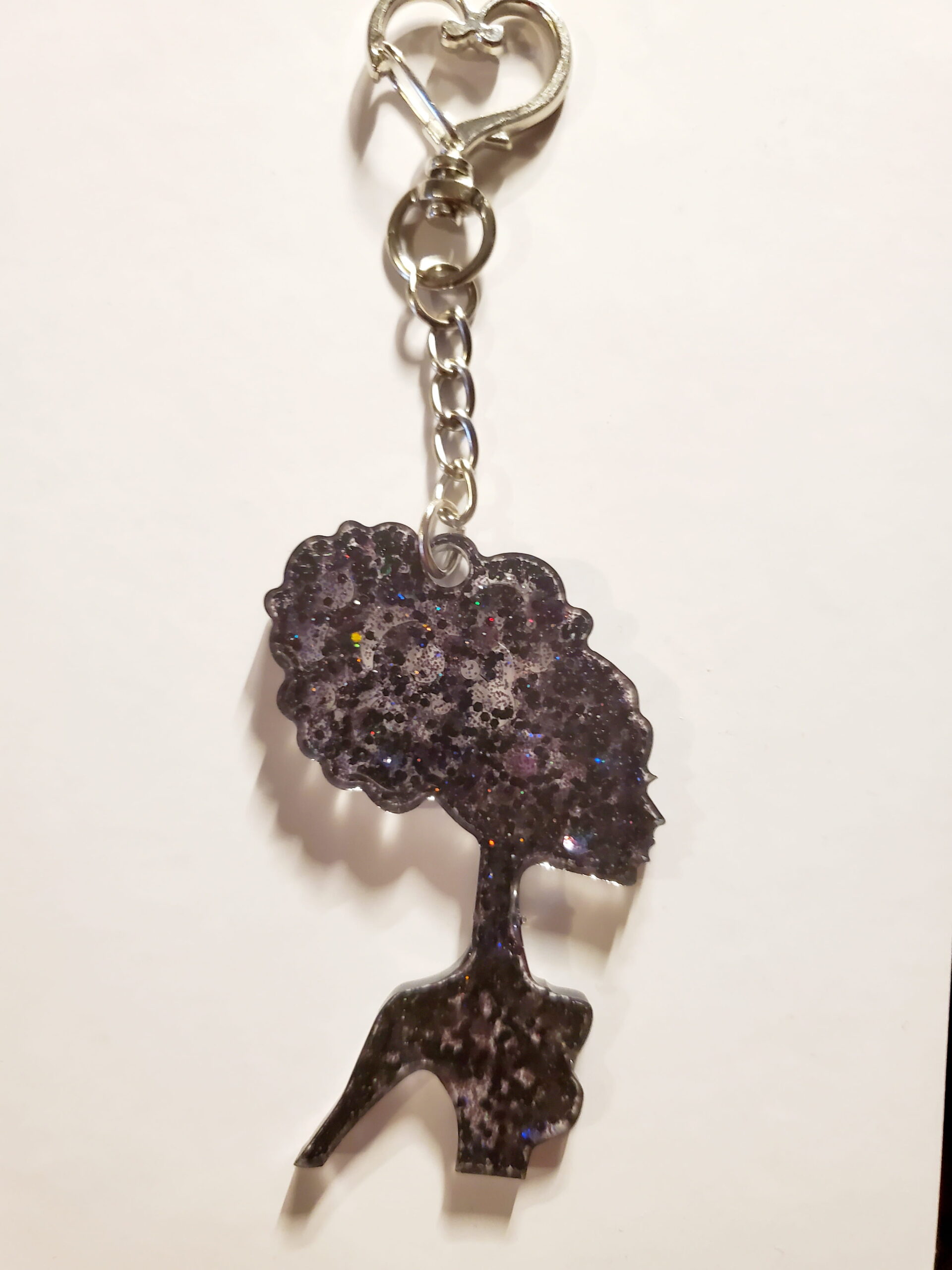 heart-shaped keychain hook with a resin mold shaped as a woman with updo hair style with black glitter decorations