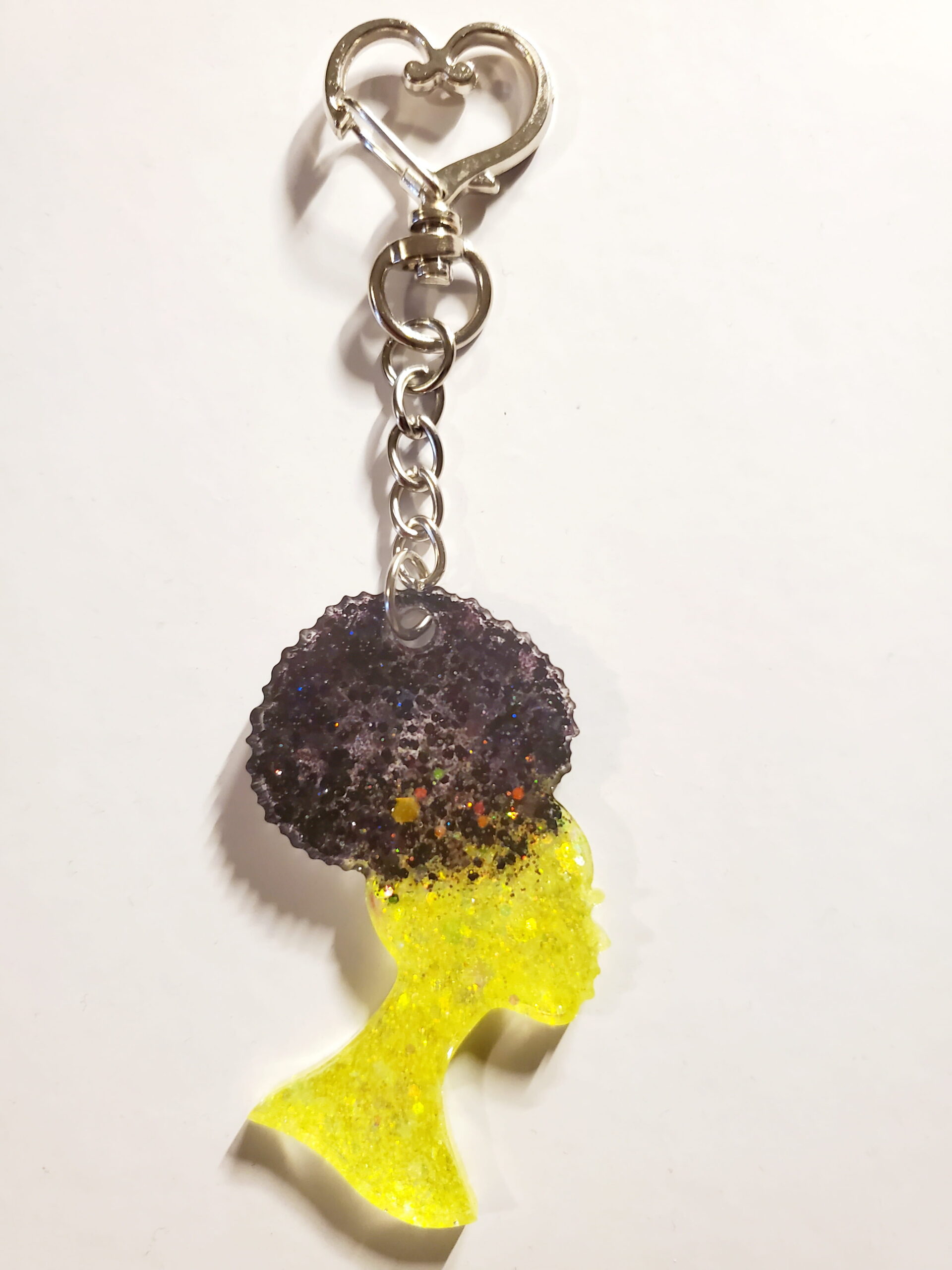 heart-shaped keychain hook with a resin mold shaped as a woman with an up-do afro hair style with yellow and black glitter decorations