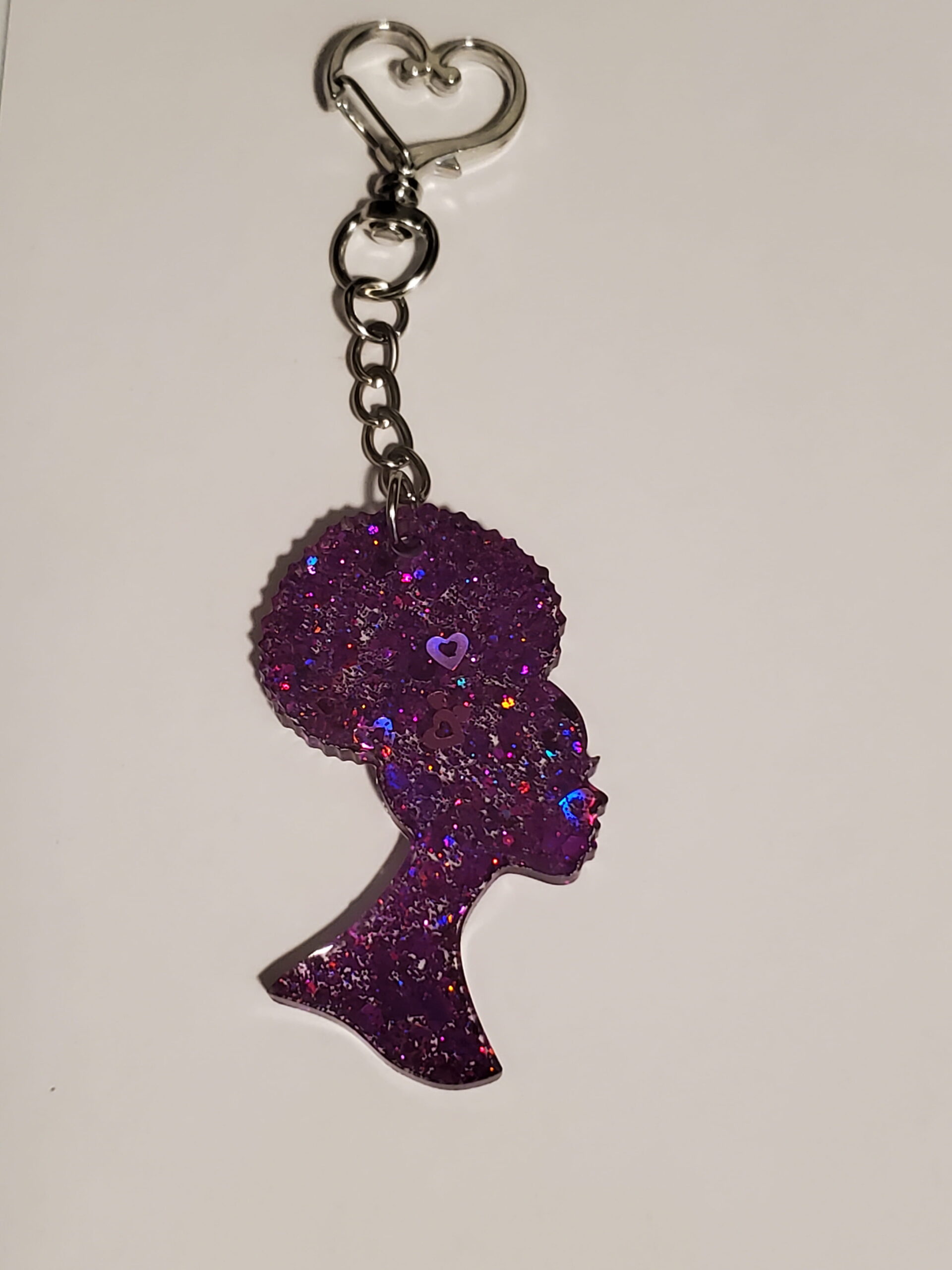 heart-shaped keychain hook with a resin mold shaped as a woman with up-do afro hairstyle with purple glitter decorations