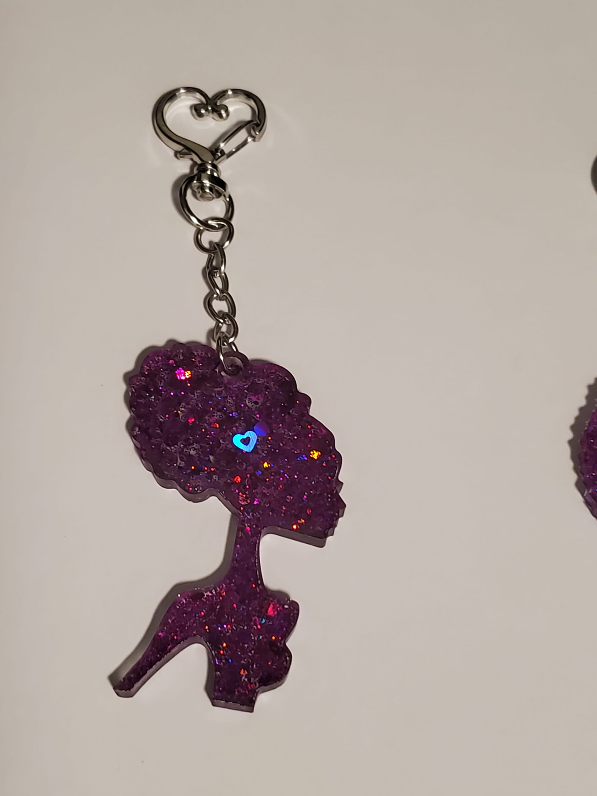 heart-shaped keychain hook with a resin mold shaped as a woman with up-do hairstyle with purple glitter decorations